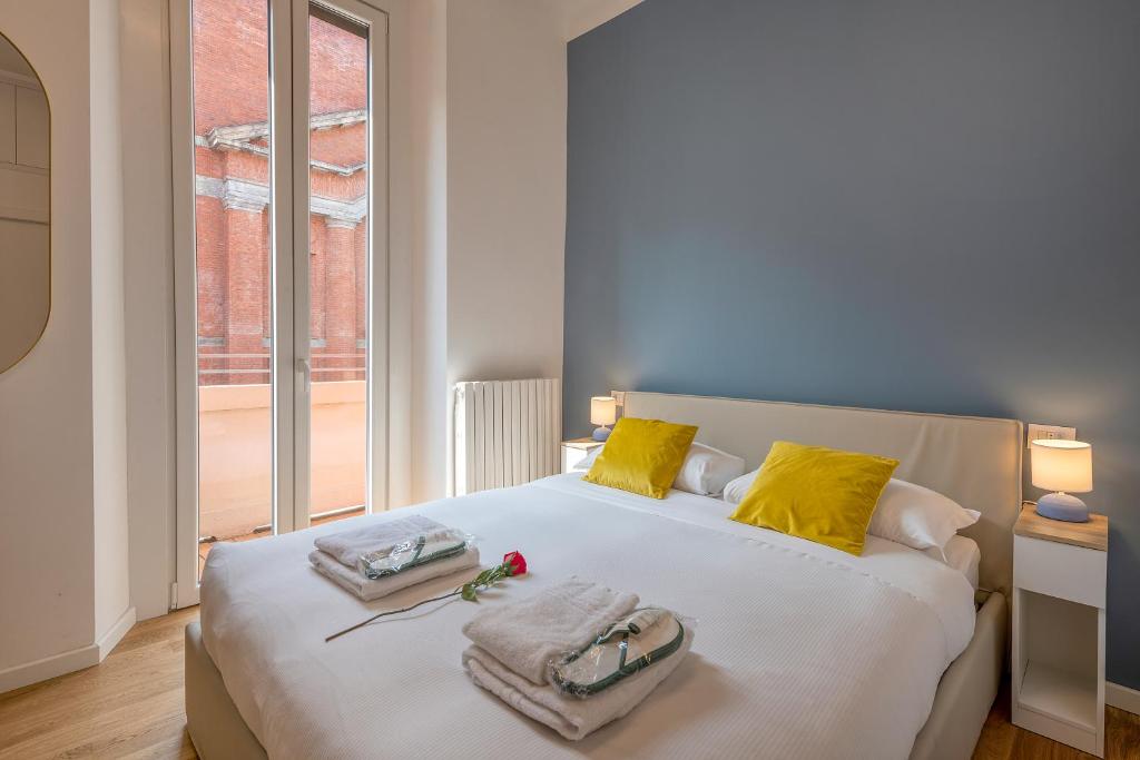 米兰BnButler - Sebenico, 28 - Nuovissimo Appartamento in Isola的卧室配有一张带黄色枕头的大型白色床。