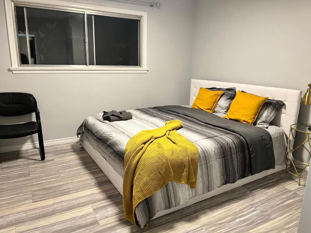 埃德蒙顿Spacious room with TV, Wi-Fi, Netflix, Parking的一间卧室配有一张带黄色枕头的床和一扇窗户