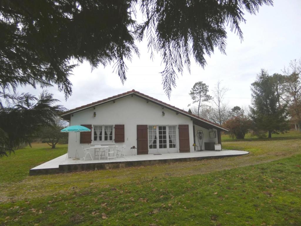 BasconsGite la touque的一座白色的小房子,在田野上配有雨伞