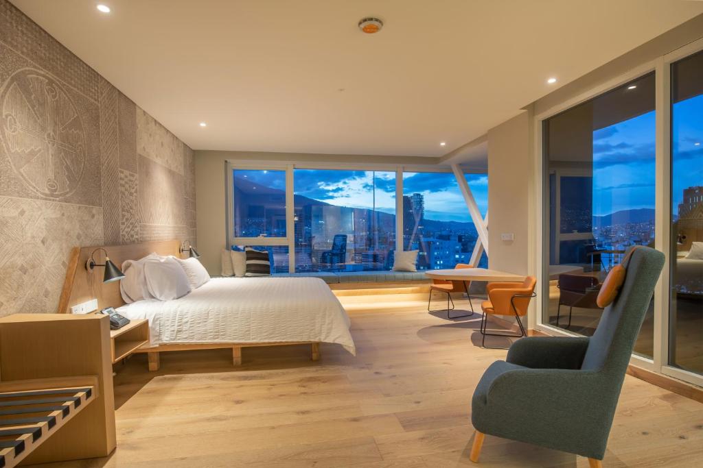 基多GO Quito Hotel的一间卧室设有一张床和一个大窗户