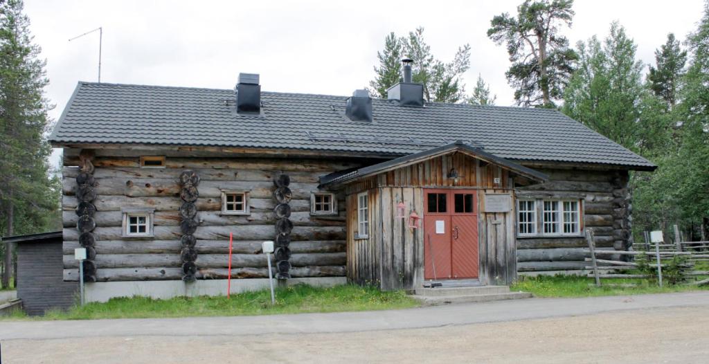 萨利色尔卡Kuukkeli Apartments Pikku-Hirvas ja Porotokka的一间设有红色门的小小木屋