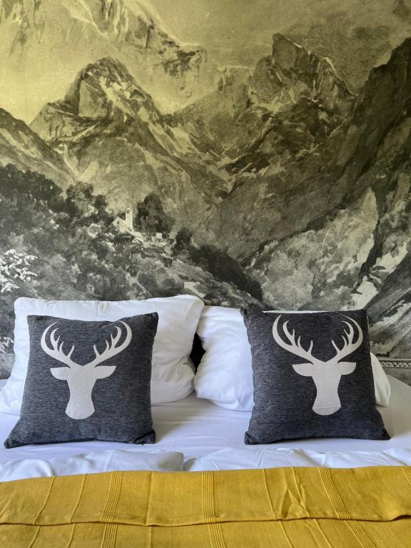 洛贝格Bavaria Mountain Lodge SKI Arber Osser Bayrischer Wald DESIGNER Ferienwohnung的一张带两个枕头的床,上面有鹿头画