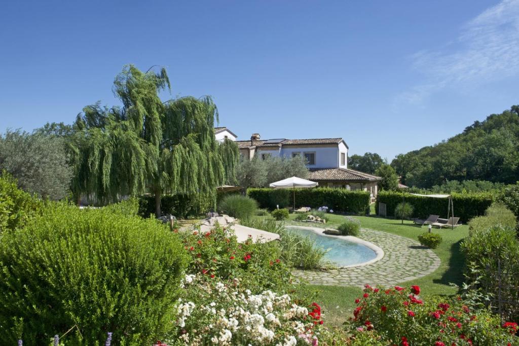 Belforte del ChientiCoroncina的一个带游泳池和房子的花园