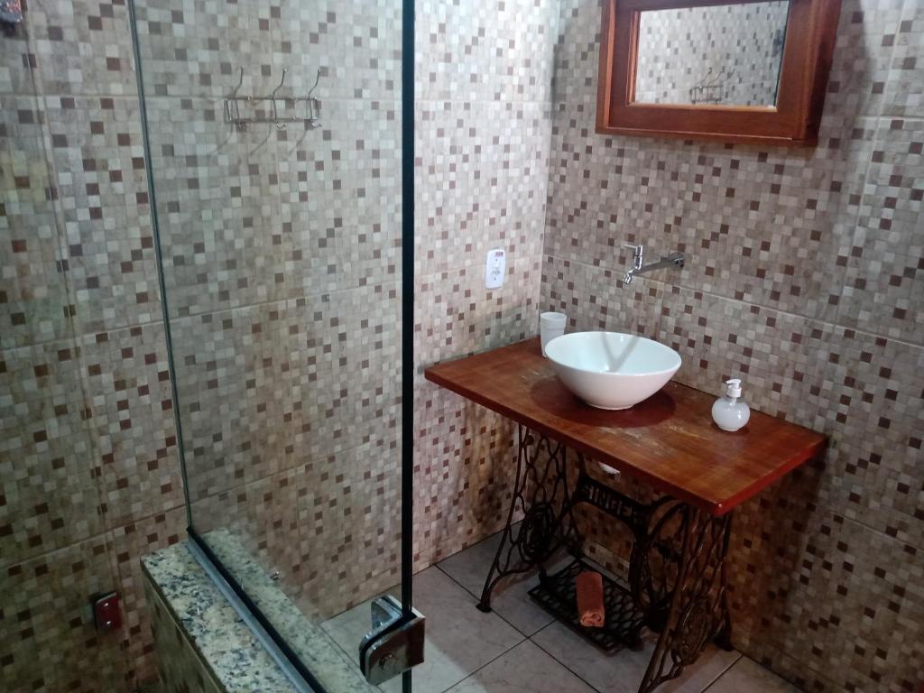 卢米亚Pousada luar da serra的一间带水槽和玻璃淋浴的浴室