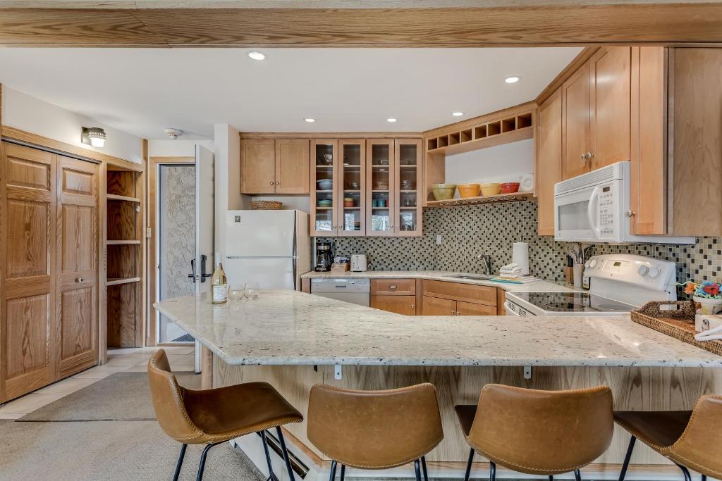 斯诺马斯村Laurelwood Condominiums 105的厨房配有木制橱柜和大台面