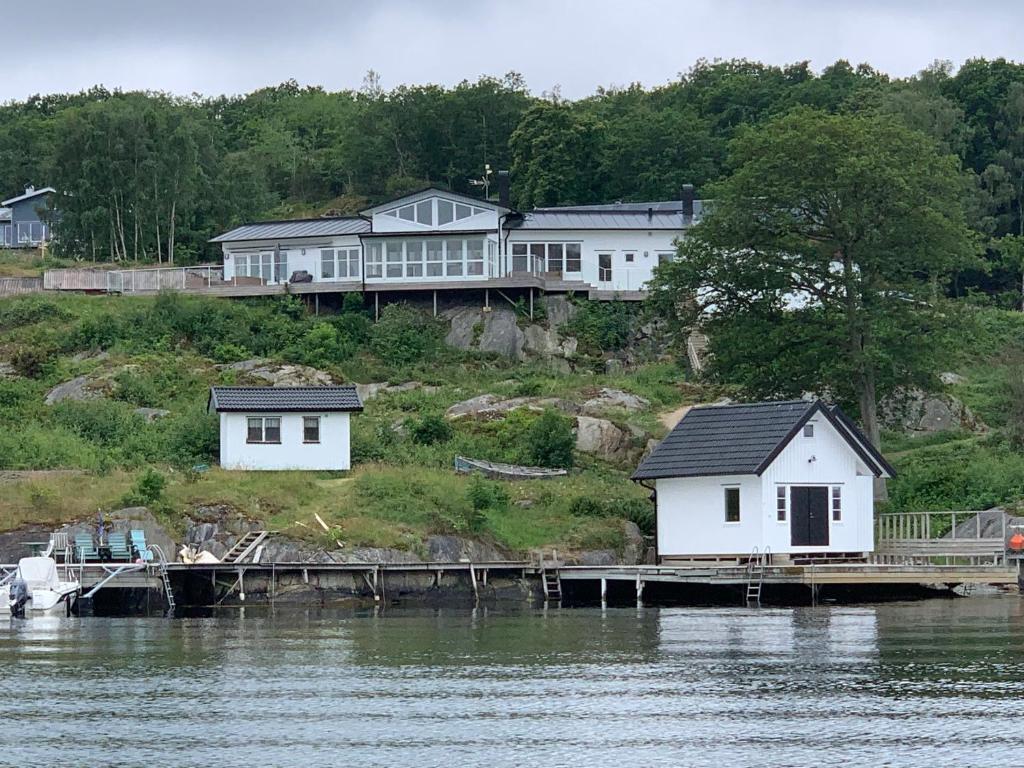NösundExclusive house with private boathouse的水体边的几座白色房子