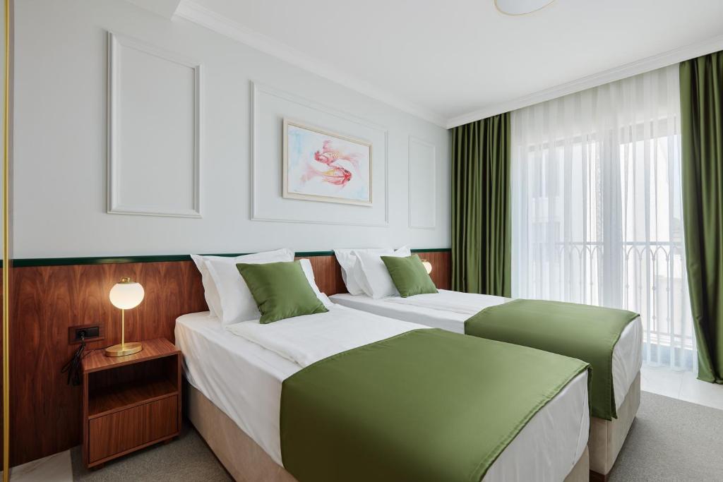 布德瓦Hotel Diplomat的酒店客房设有两张床和窗户。