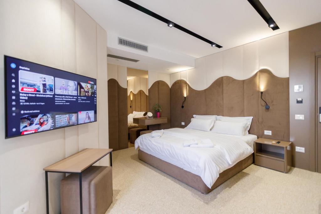 伏罗拉Hotel PortSide GF的一间卧室配有一张大床和一台平面电视
