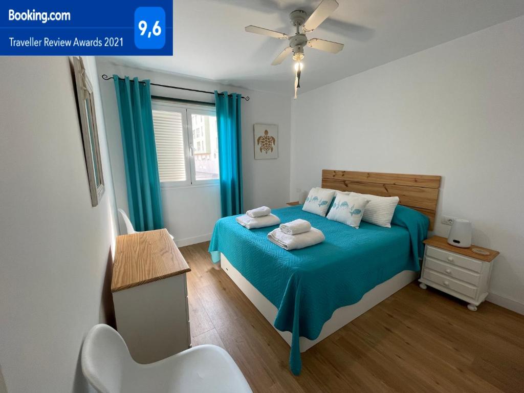 厄尔梅达诺The Beach House的一间卧室配有蓝色的床和毛巾