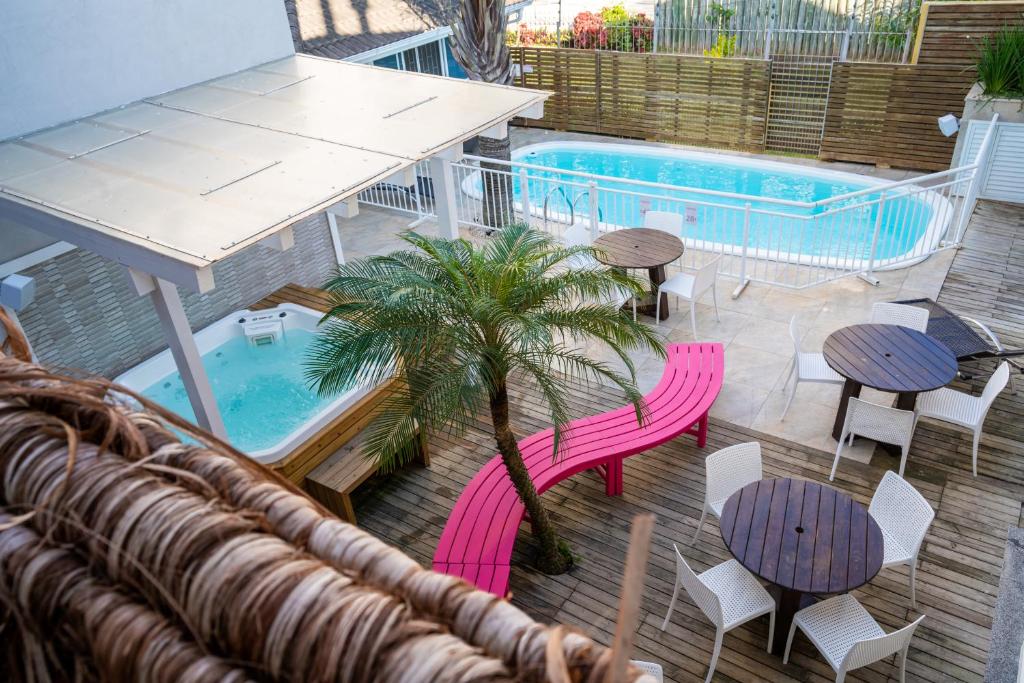 弗洛里亚诺波利斯Bossa Jurerê Hotel的一个带桌椅的庭院和一个游泳池