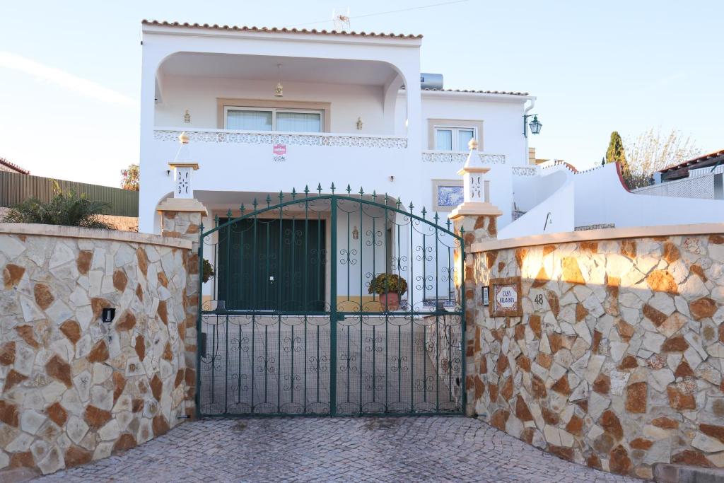 卢斯Luxury Villa with ocean view的白色的房子,有门和石墙