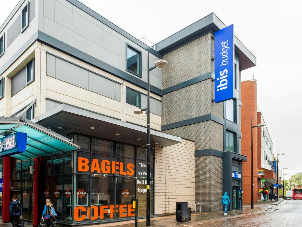 布罗姆利ibis budget London Bromley Town Centre的前面有百吉饼咖啡标志的建筑