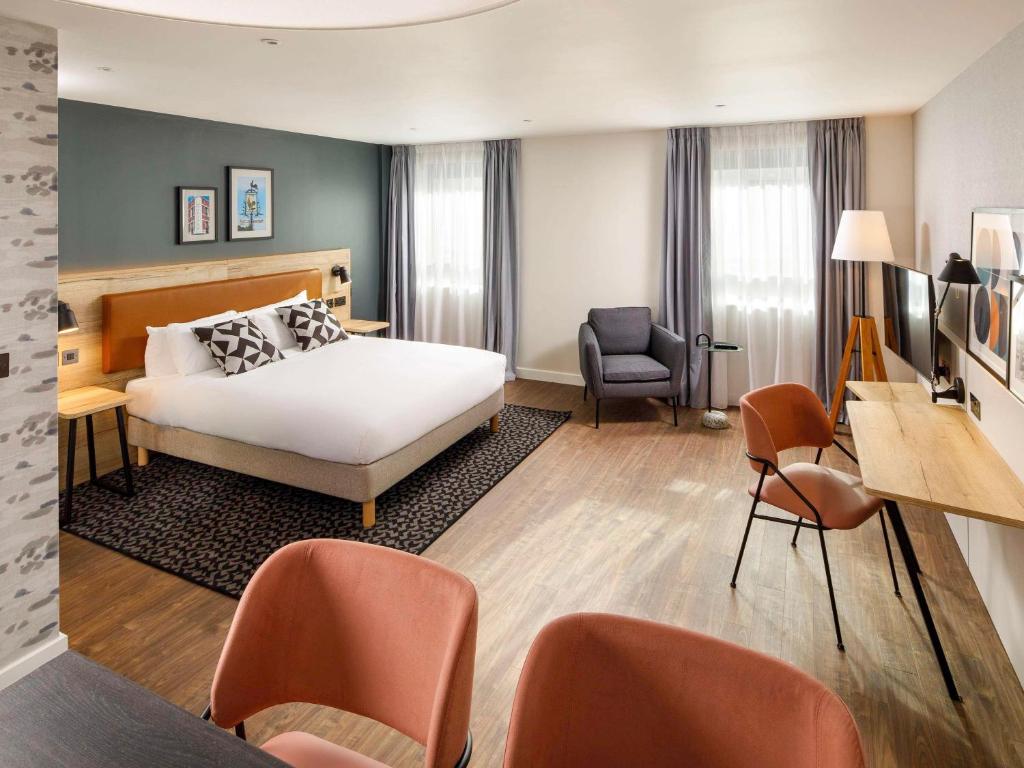 萨顿Aparthotel Adagio London Sutton Point的酒店客房,配有一张床、一张桌子和椅子
