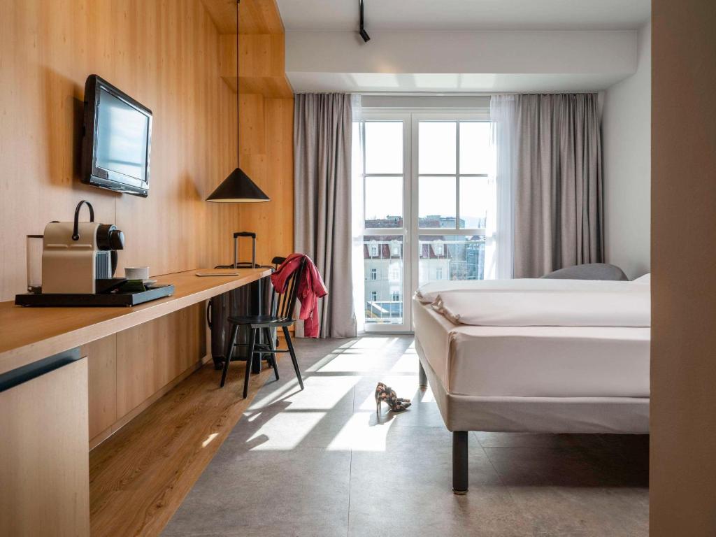 格拉茨ibis Styles Graz Messe的配有一张床和一张书桌的酒店客房