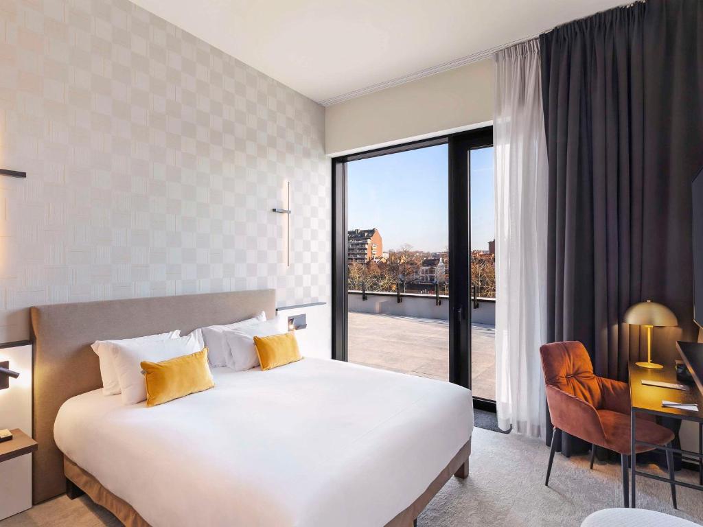 那慕尔Mercure Namur Hotel的酒店客房设有一张床和一个大窗户