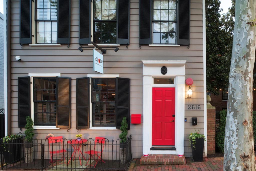 华盛顿The Poppy Georgetown Guesthouse and Gardens的一间红色门和黑色窗户的房子