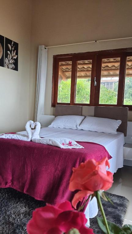 瓜拉米兰加Belaninha的一间卧室配有一张带红色毯子的床和两个窗户。