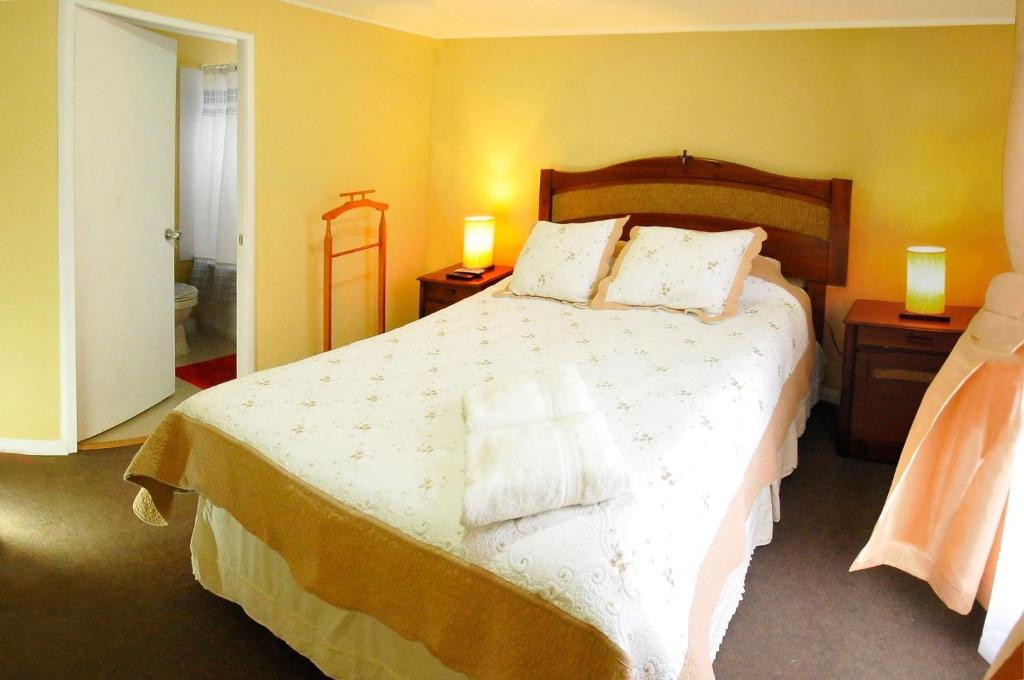 塔尔卡Alojamientos San Sebastián Talca的一间卧室配有一张带2个床头柜的大床