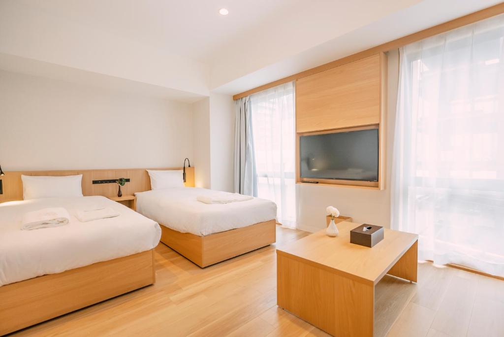 大阪谷町君Hotel 難波77的一间酒店客房,设有两张床和电视