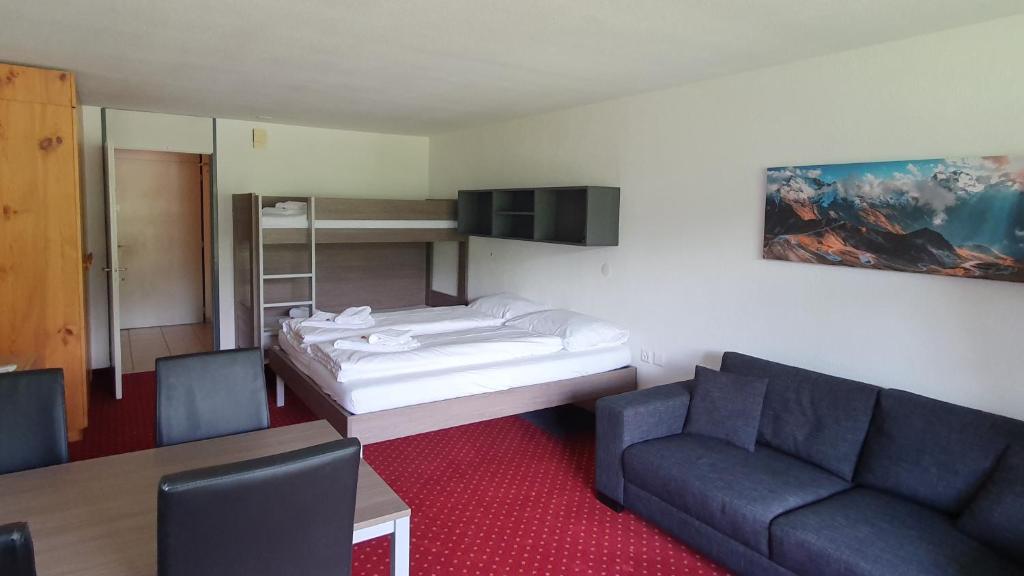 迪森蒂斯豪斯阿克莱塔度假公寓的客房设有床、沙发和桌子。
