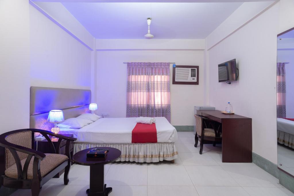 吉大港Hotel Golden Inn Chattagram Ltd的一间卧室配有一张床、一张书桌和一张书桌
