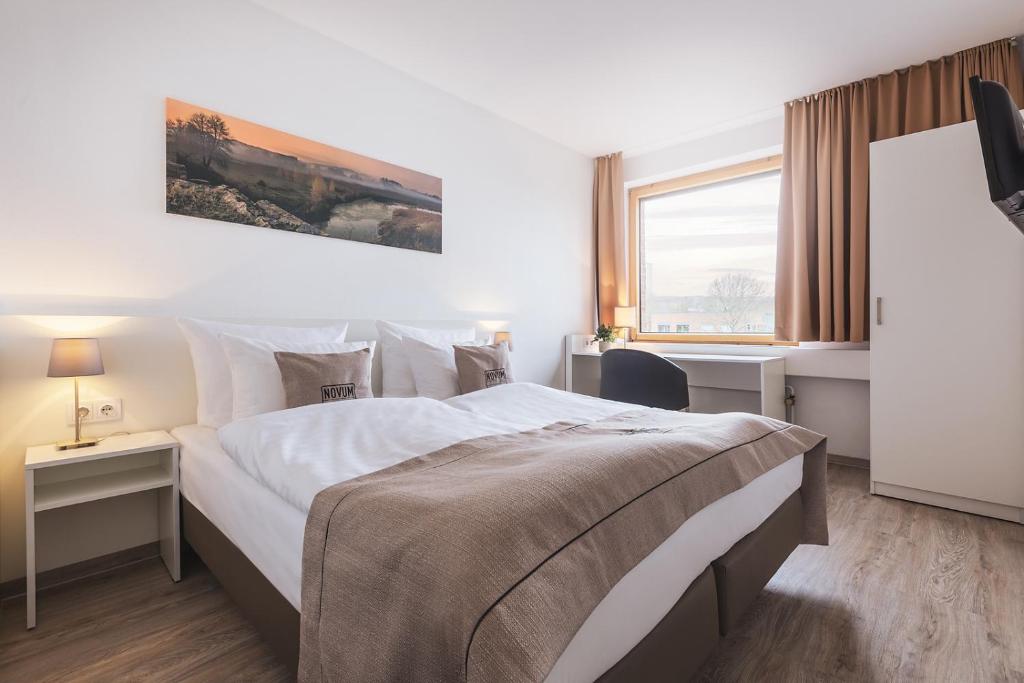 基尔基尔阿卡德米尔诺富姆酒店的一间设有大床和窗户的酒店客房