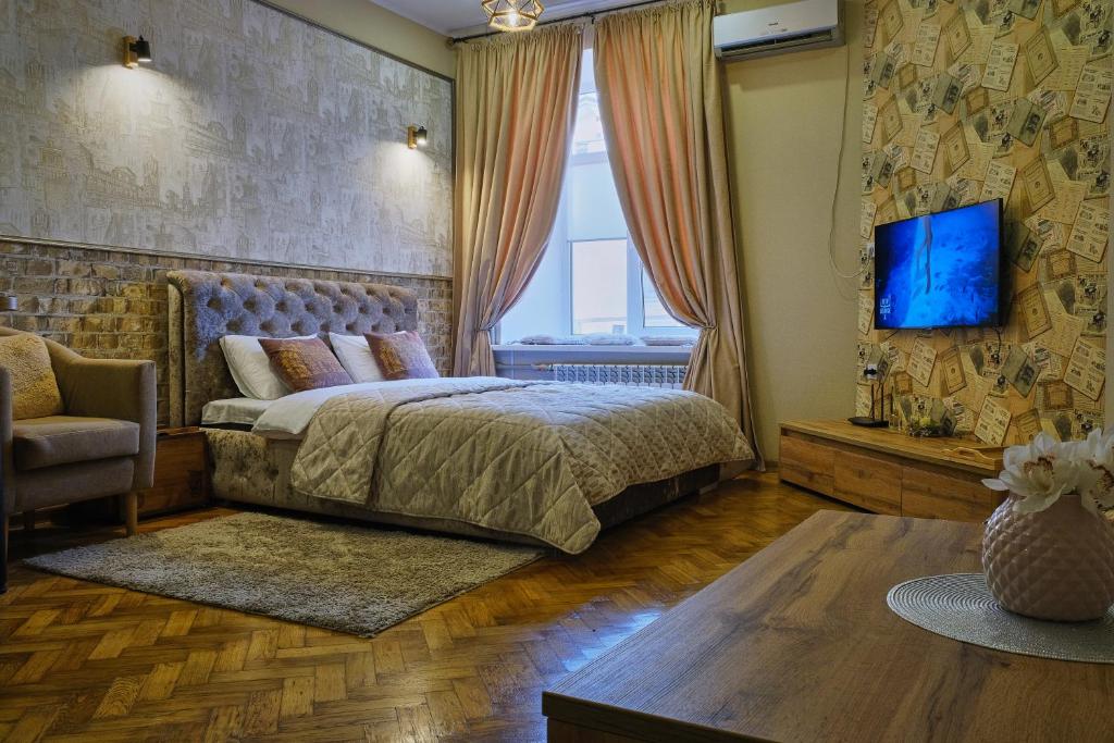 敖德萨Central Apartments的一间卧室配有一张床,墙上配有电视