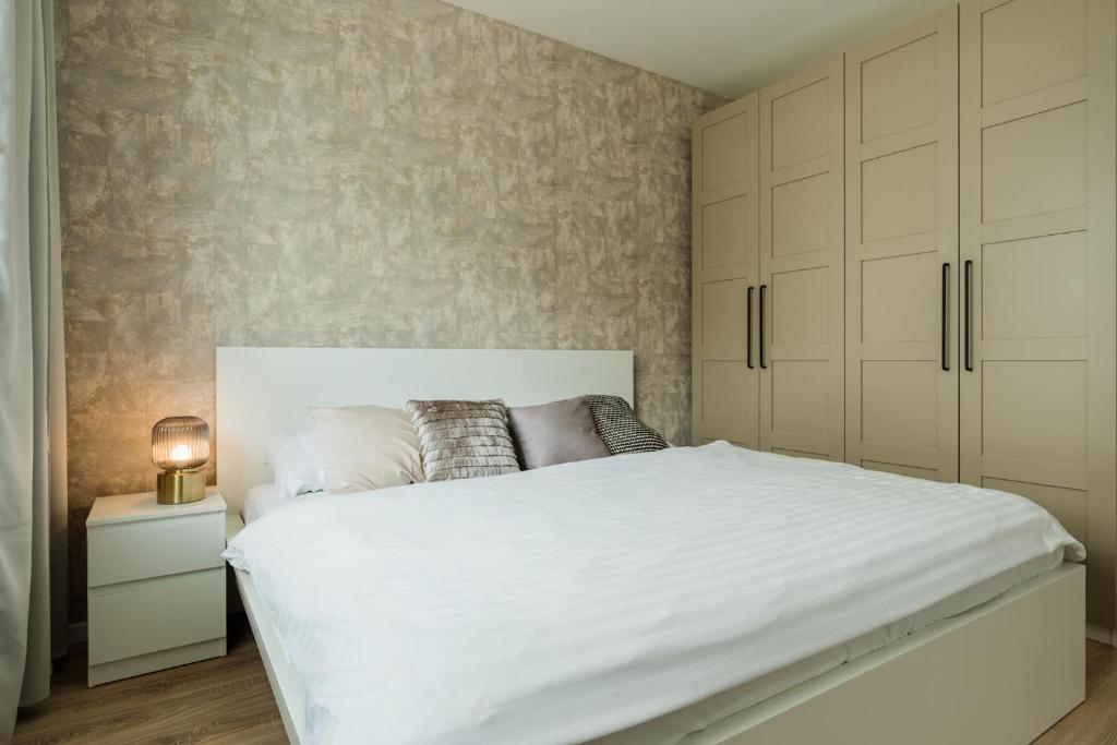 PrievozUrban & Green Apartments by Ambiente的卧室配有一张白色大床和橱柜。