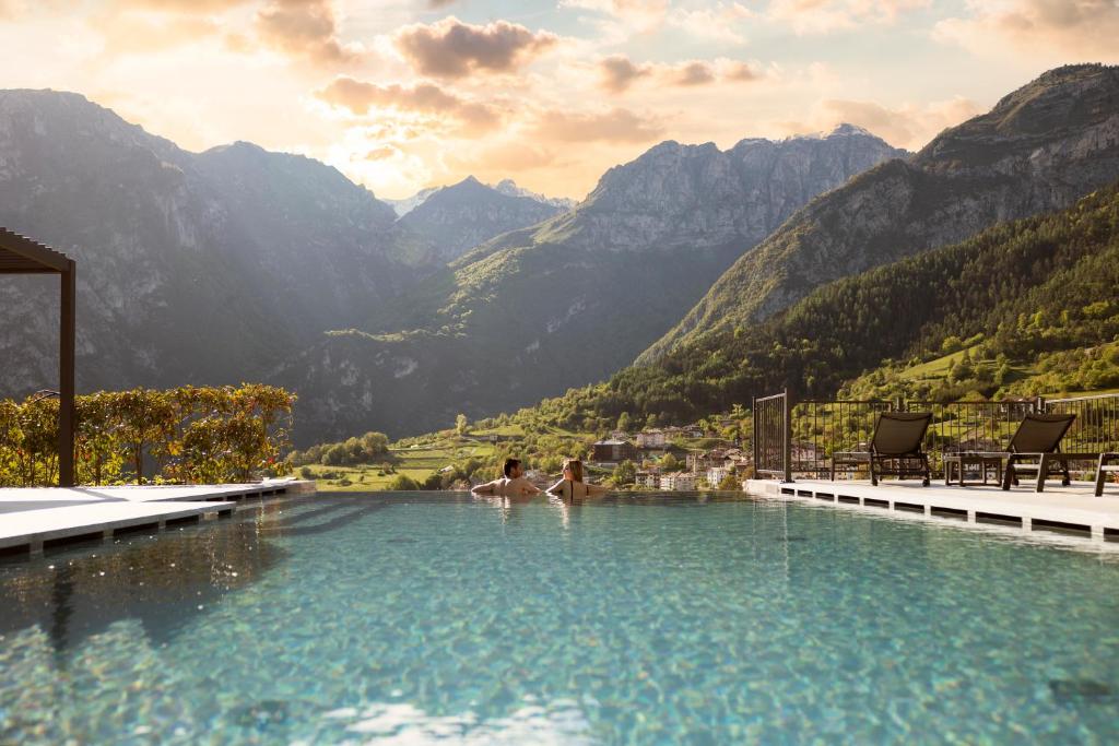 圣洛伦佐因巴纳莱Hotel Castel Mani的两人在山地游泳池游泳