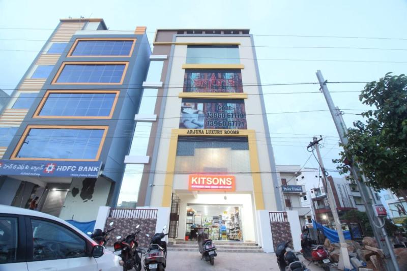 海得拉巴Arjuna Luxury Rooms的停在前面的摩托车建筑