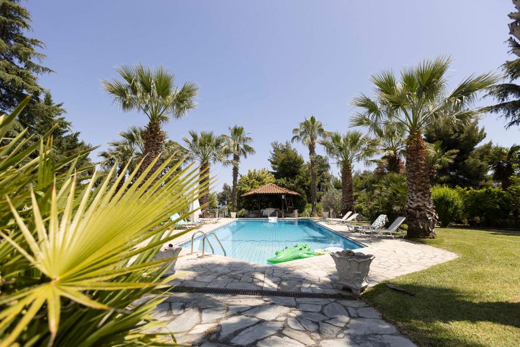 克里皮吉#FLH - Coconut & Vanilla & Pineapple Pool Apartments的棕榈树庭院内的游泳池