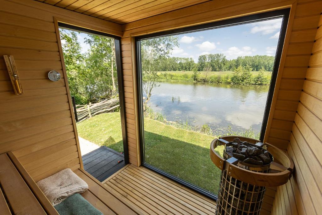 代因泽Leie Villa II - by the river with sauna & jacuzzi的享有湖景的门廊屏风