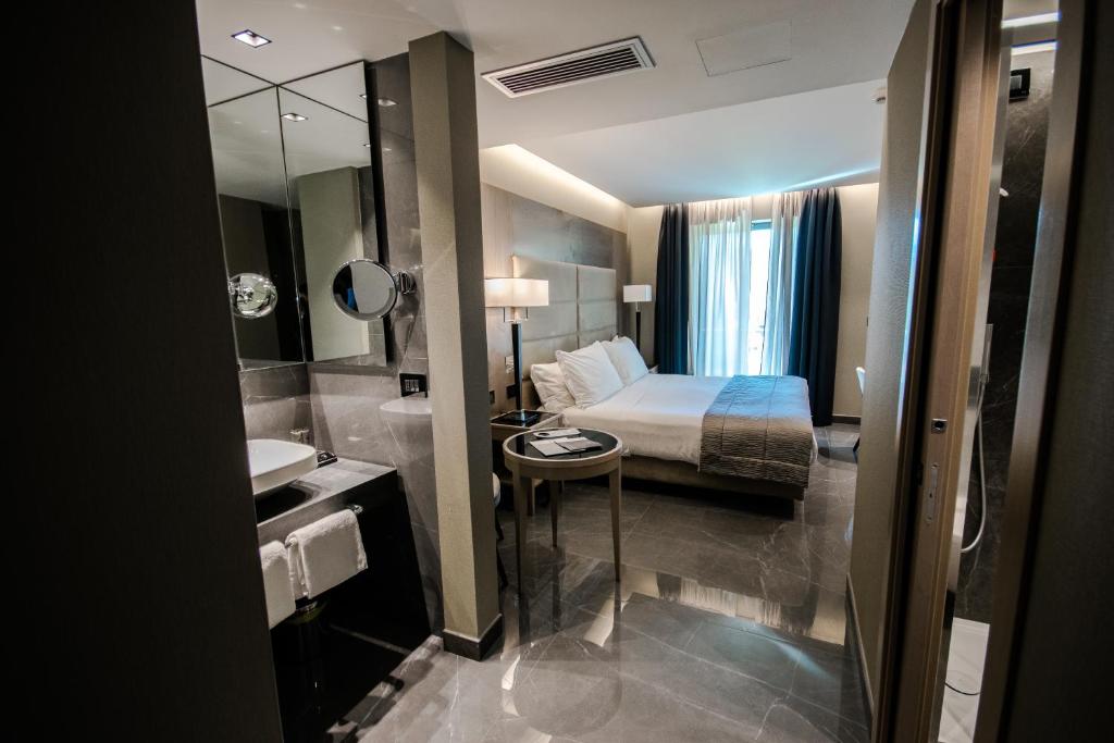 庞贝论坛酒店的酒店客房设有床和水槽