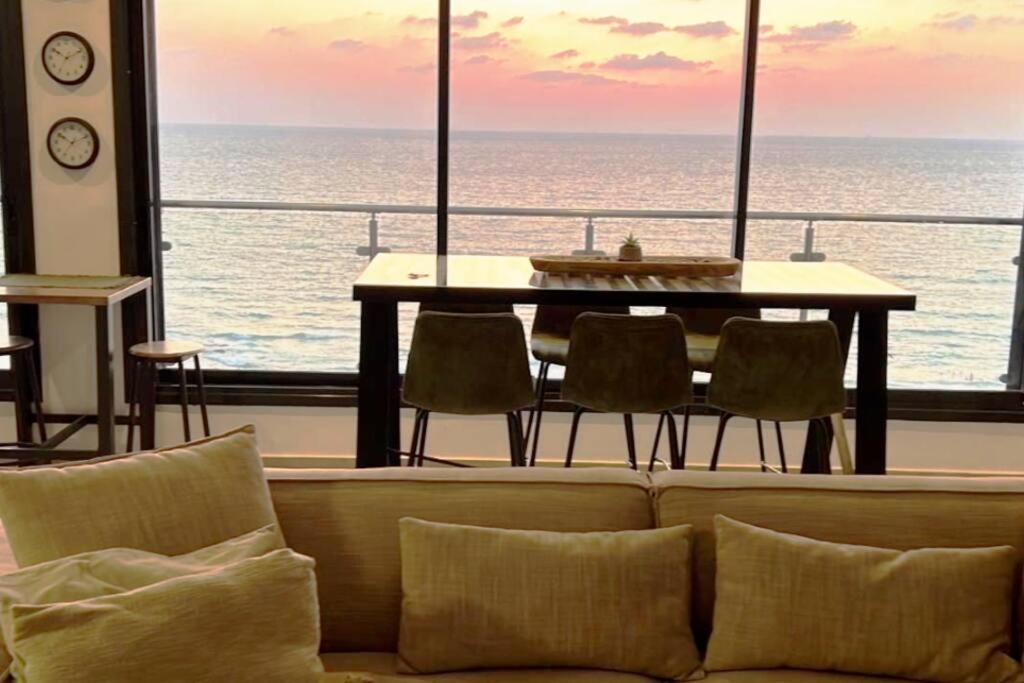 巴特亚姆The Kingdom On The Beach的客厅配有沙发和桌子,享有海景。