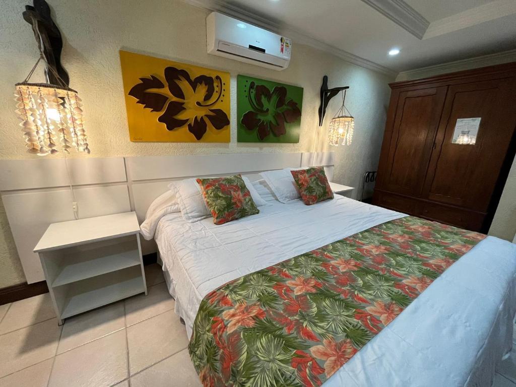 邦比尼亚斯Pousada Kaloa Eco Village的一间卧室配有一张大床,配有白色的床罩和防过敏设施。