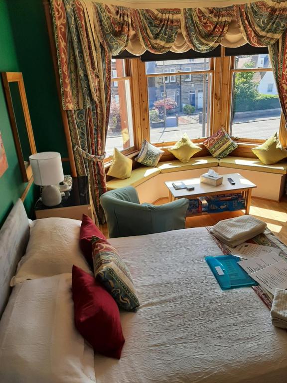 爱丁堡别间住宿加早餐旅馆的一间卧室设有一张大床和一个大窗户