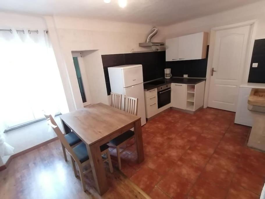 洛夫兰Apartment in Lovran的厨房铺有木地板,配有木桌。