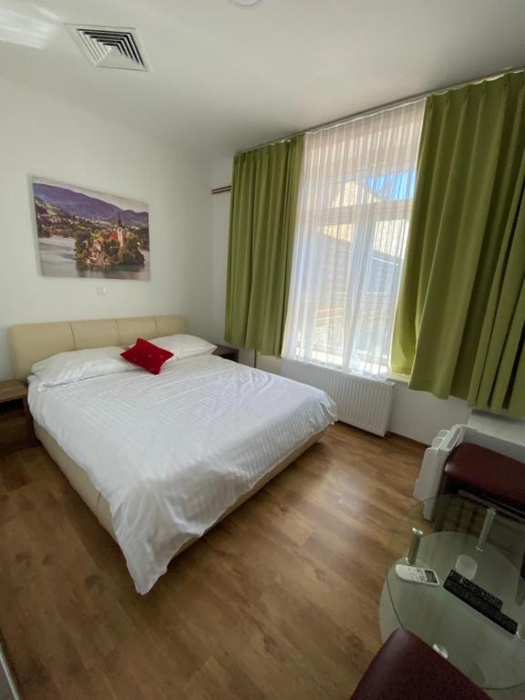 科济纳PENZION FARAON - CASINO ALFASTREET的一间卧室配有一张床、一张书桌和绿色窗帘