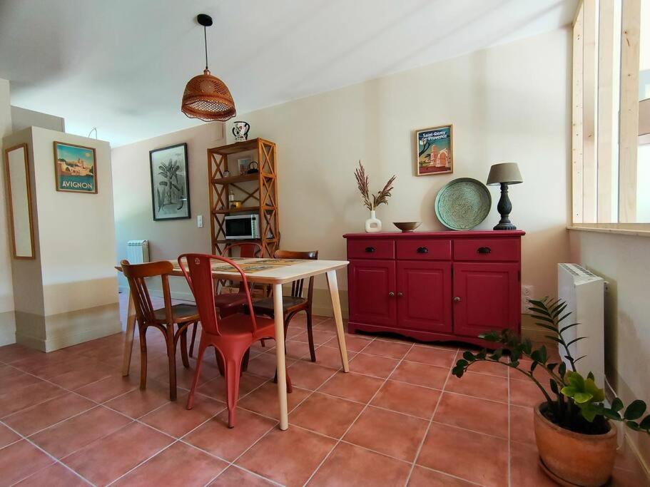 沙托雷纳尔Dolce Vita en Provence的一间带桌椅和红色橱柜的用餐室