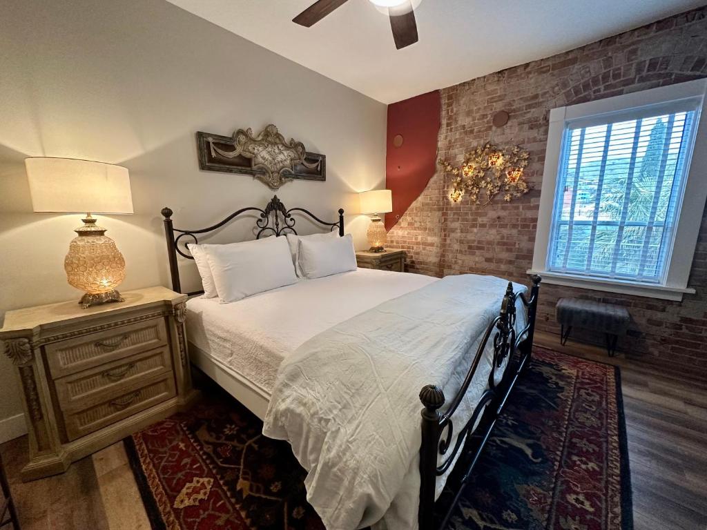 比斯比Bisbee Brownstone Suites的一间卧室设有一张床和砖墙