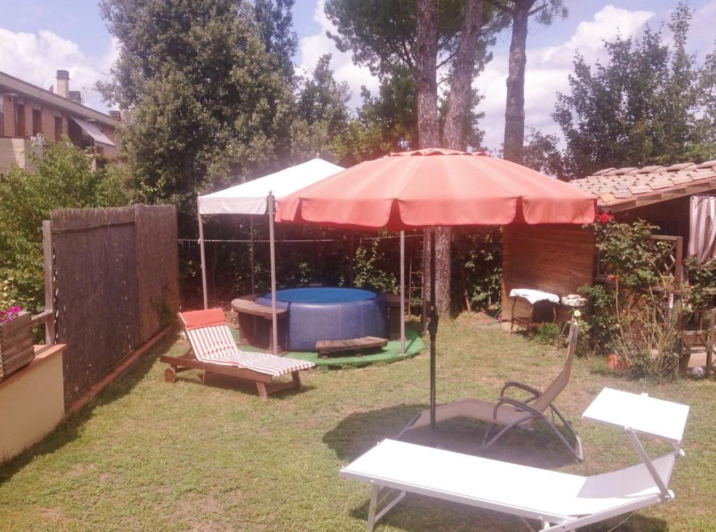 基安蒂格雷夫B&B Casa Gori的一个带遮阳伞和热水浴缸的庭院
