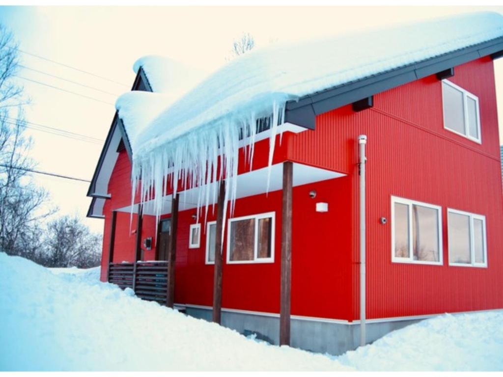二世古niseko / Vacation STAY 4376的雪覆盖着的红色房子,上面有 ⁇ 石