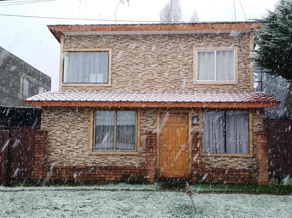 科伊艾科CABAÑAS TRAPAGONIA的雪中带门的砖房
