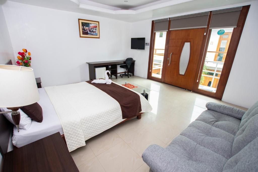 巴克里索莫雷诺港Blue Marlin Hotel的一间卧室配有一张床和一张沙发