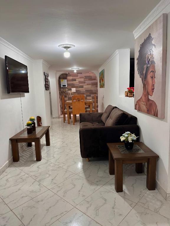 麦德林Acogedor apartamento cerca al centro de Medellin的客厅配有沙发和2张桌子