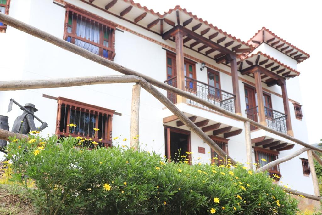 莱瓦镇Casa El Retiro - Villa de Leyva的前方有窗户和鲜花的建筑