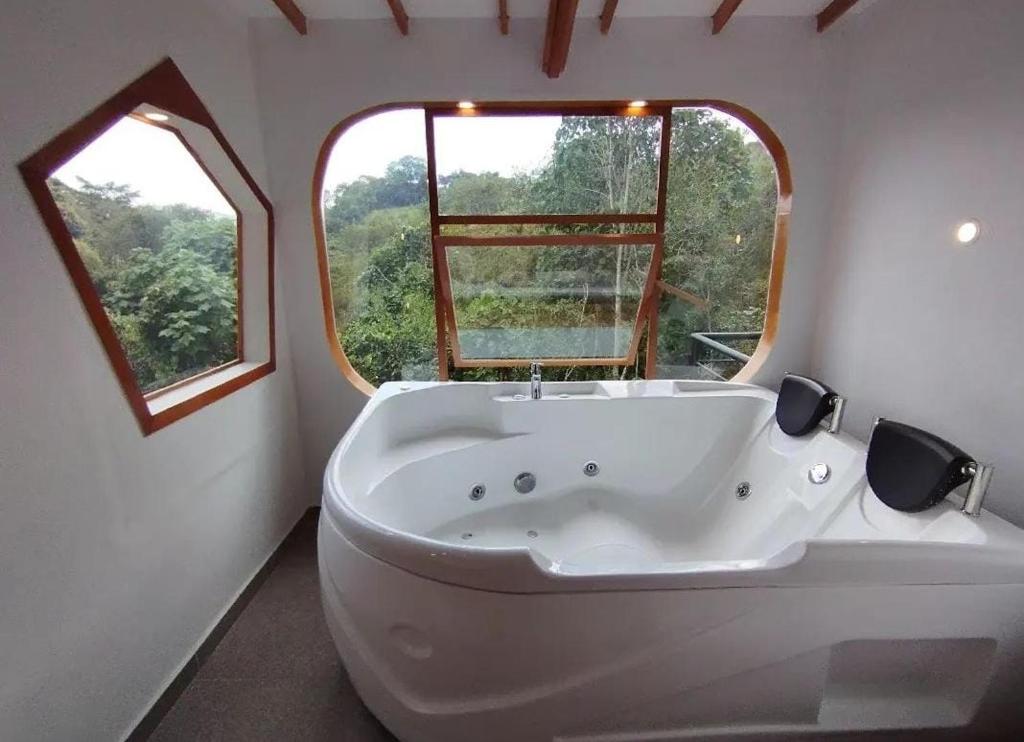 圣奥古斯丁ASGARD Spa的带窗户的浴室内的白色大浴缸