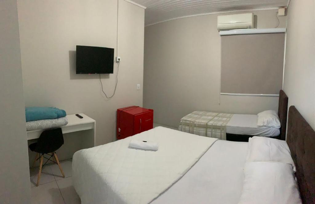 伊茹伊HOTEL LIFE IJUI的客房设有两张床、一张桌子和一台电视机。
