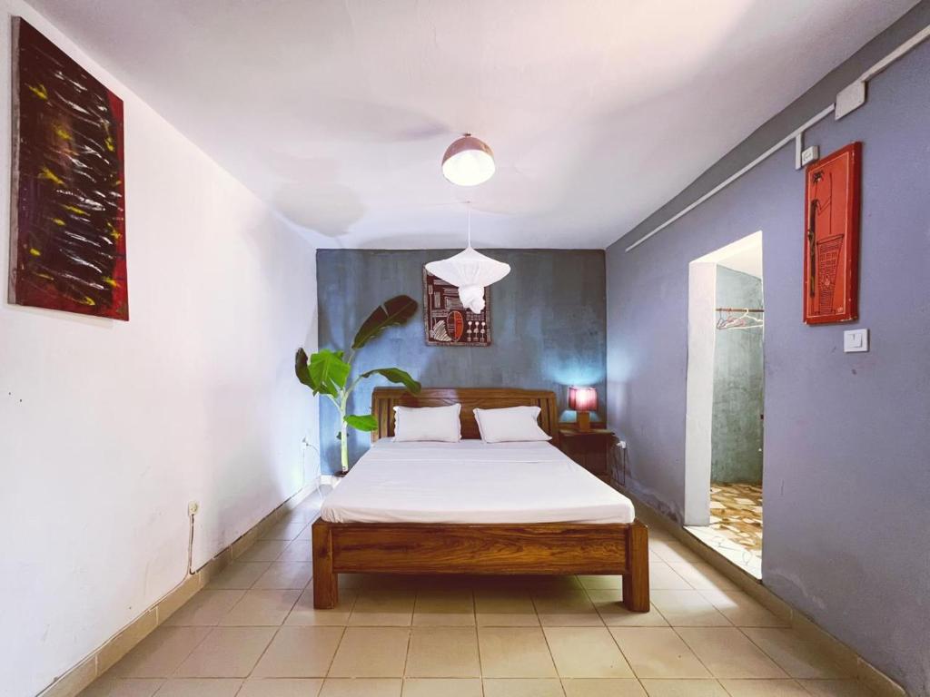 比绍Casa Cacheu low cost family house的一间卧室设有一张床和蓝色的墙壁
