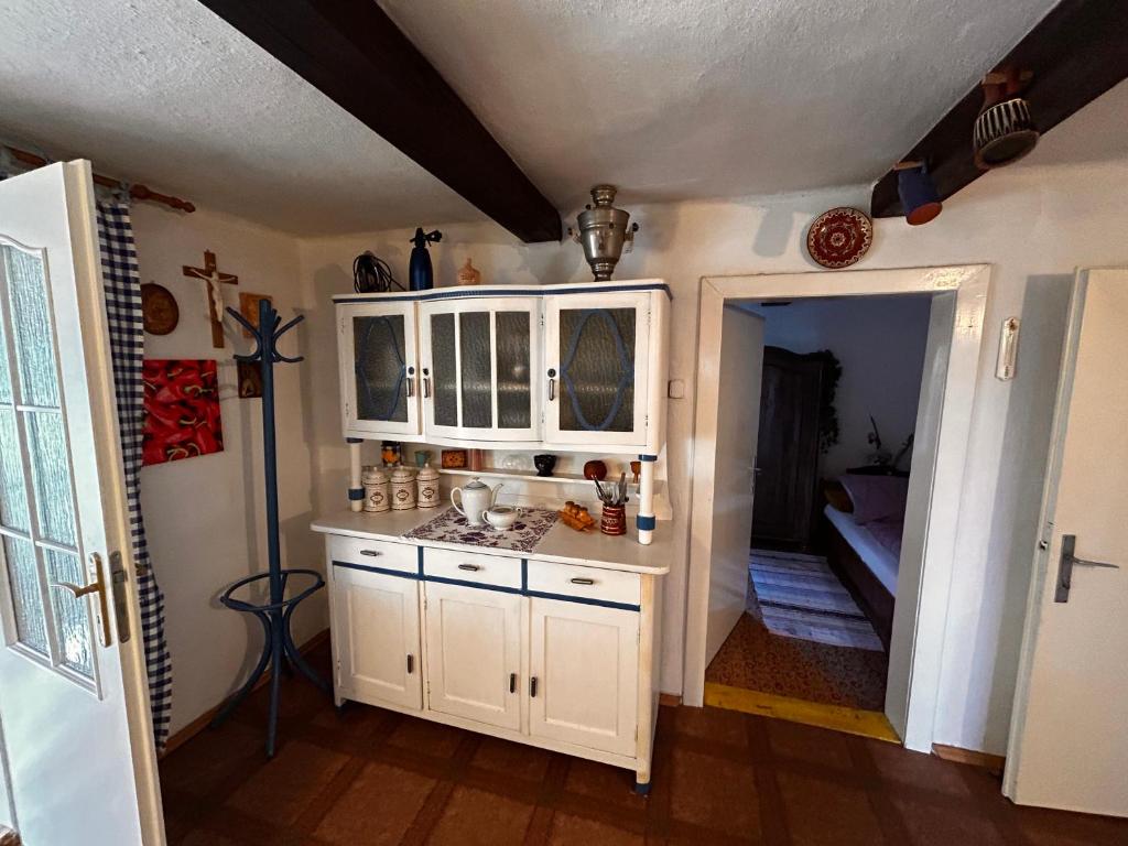 HrádekOáza klidu的一间带白色橱柜的厨房和一间带沙发的房间